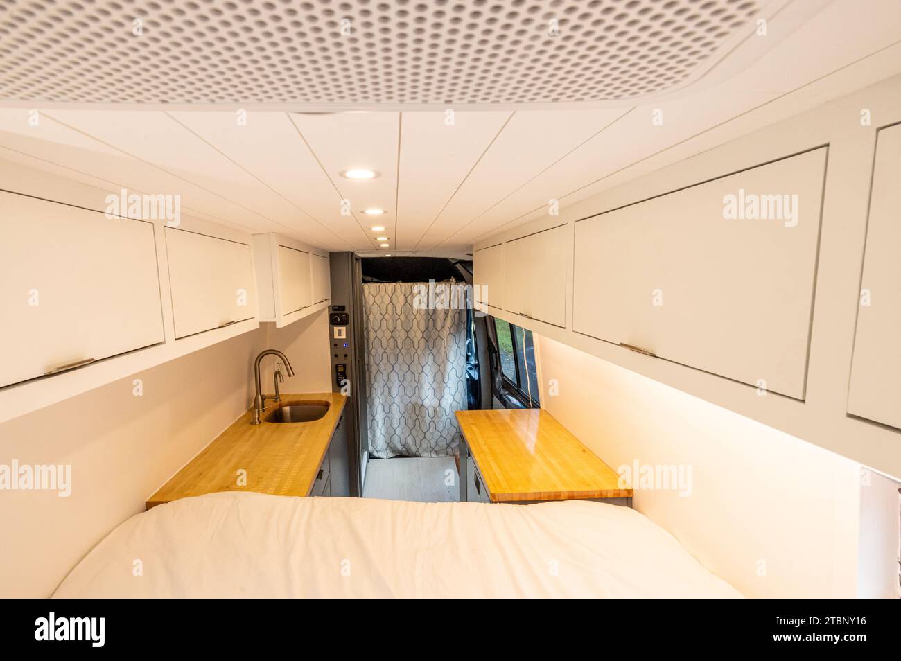 Looking toward the kitchen of a converted sprinter van camper Stock Photo