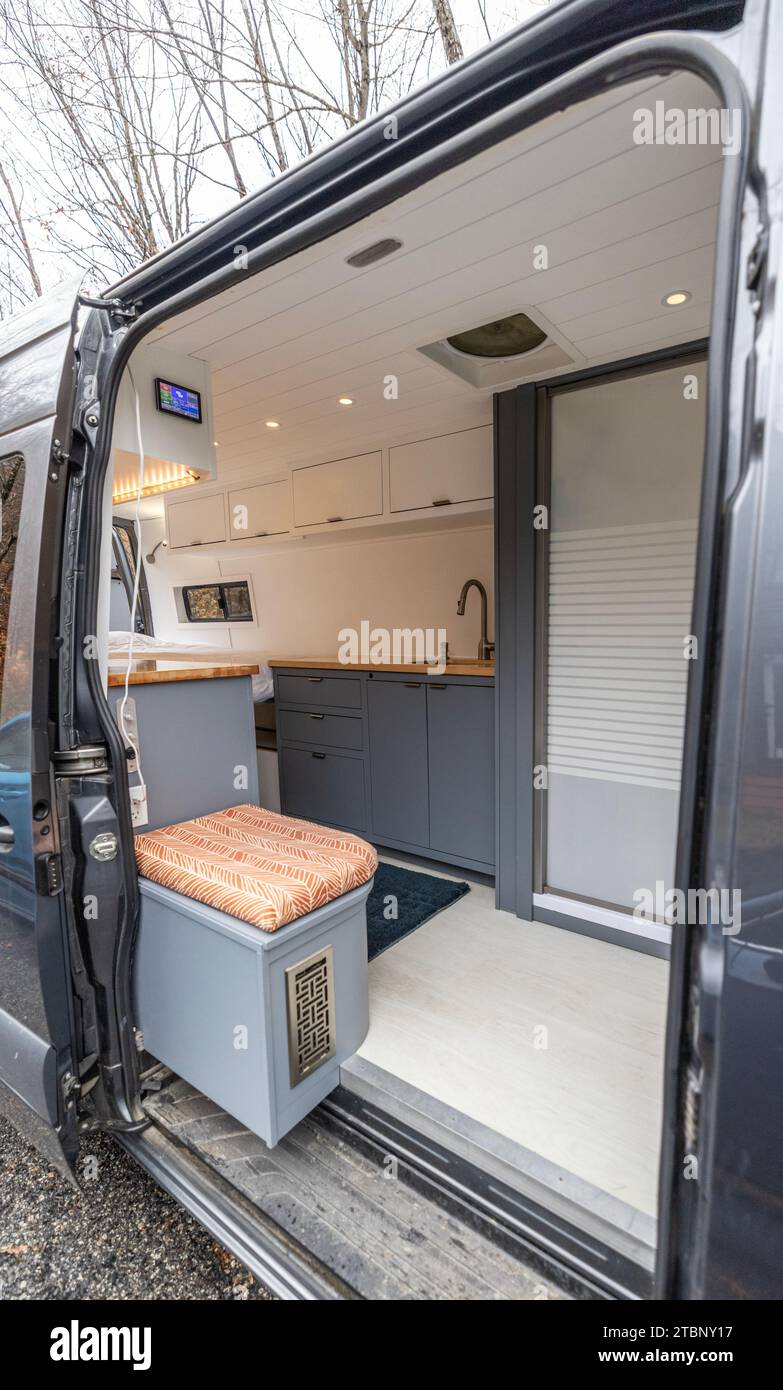 Open door of a van reveals custom camper conversion Stock Photo