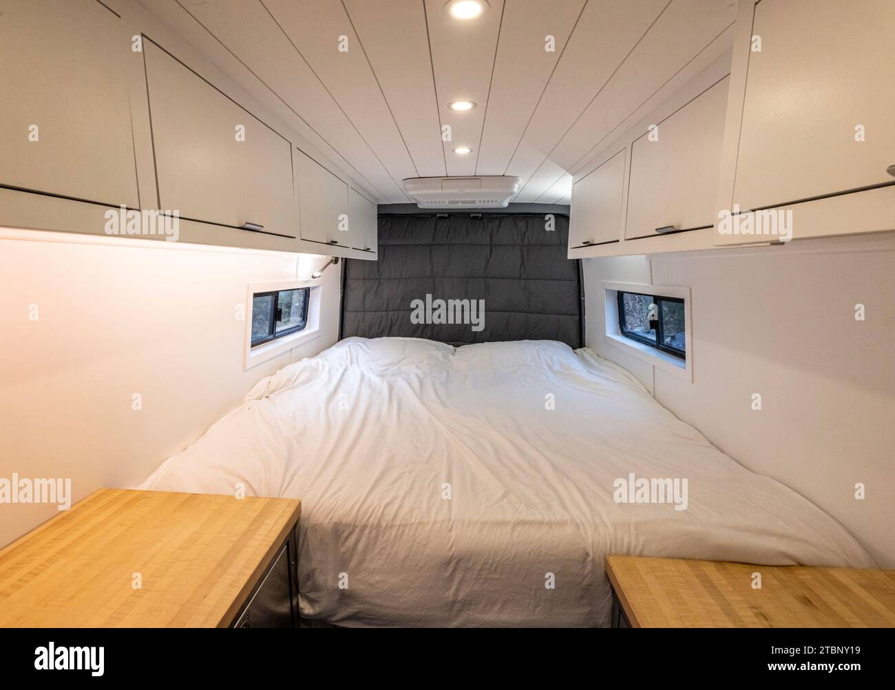 Bed room area of a converted sprinter van camper Stock Photo