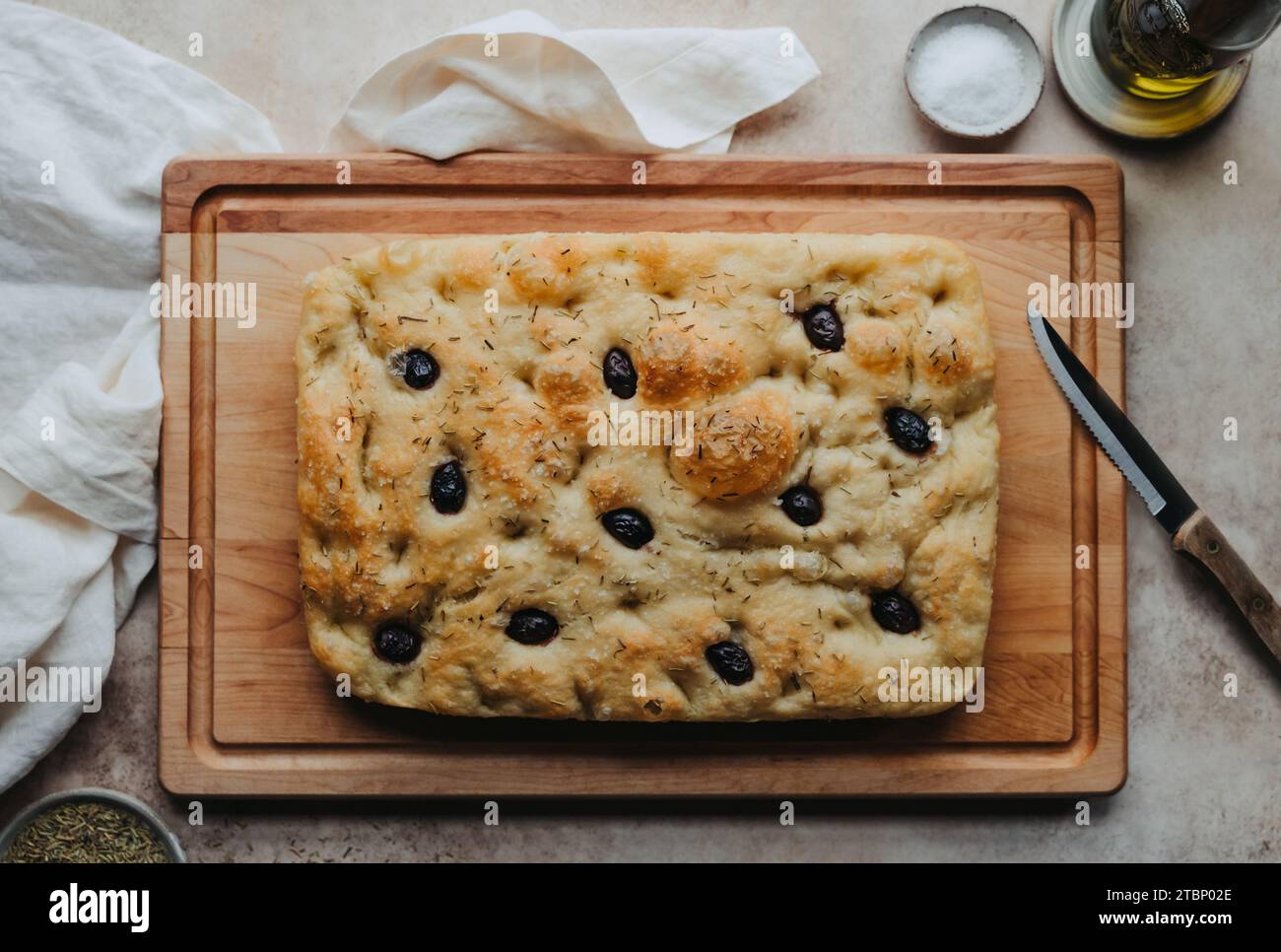 Freshly baked olive and rosemary focaccia bread on wooden board Stock ...