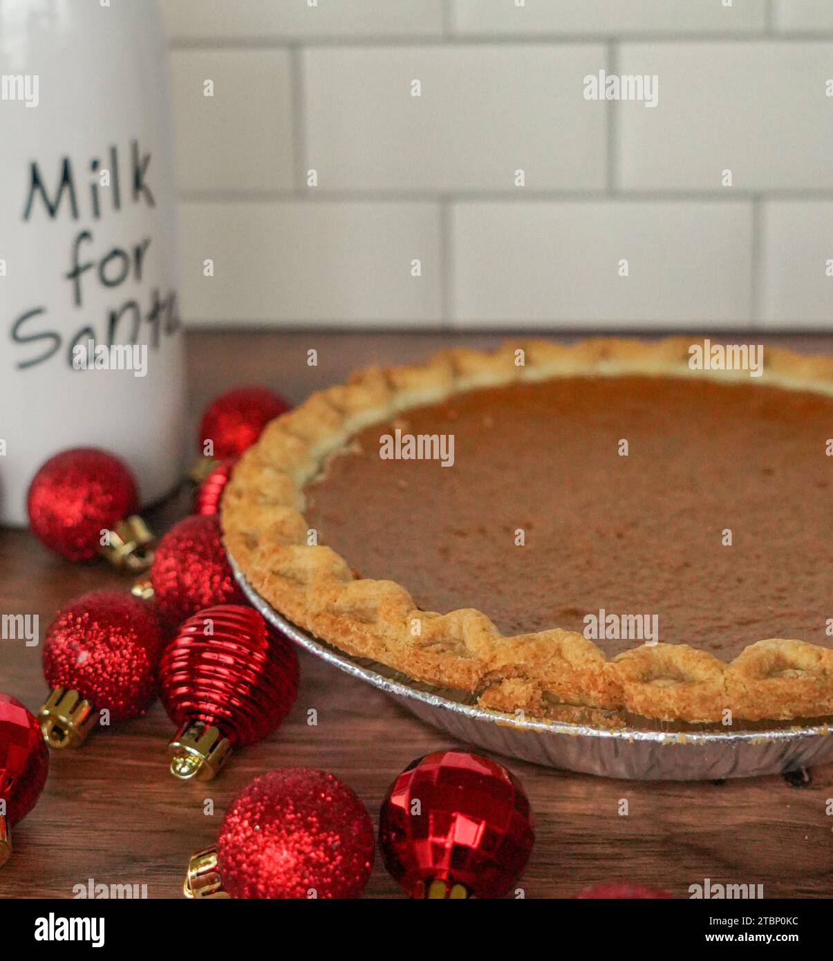 Close up of pumpkin pie with a bottle of Milk for Santa Stock Photo