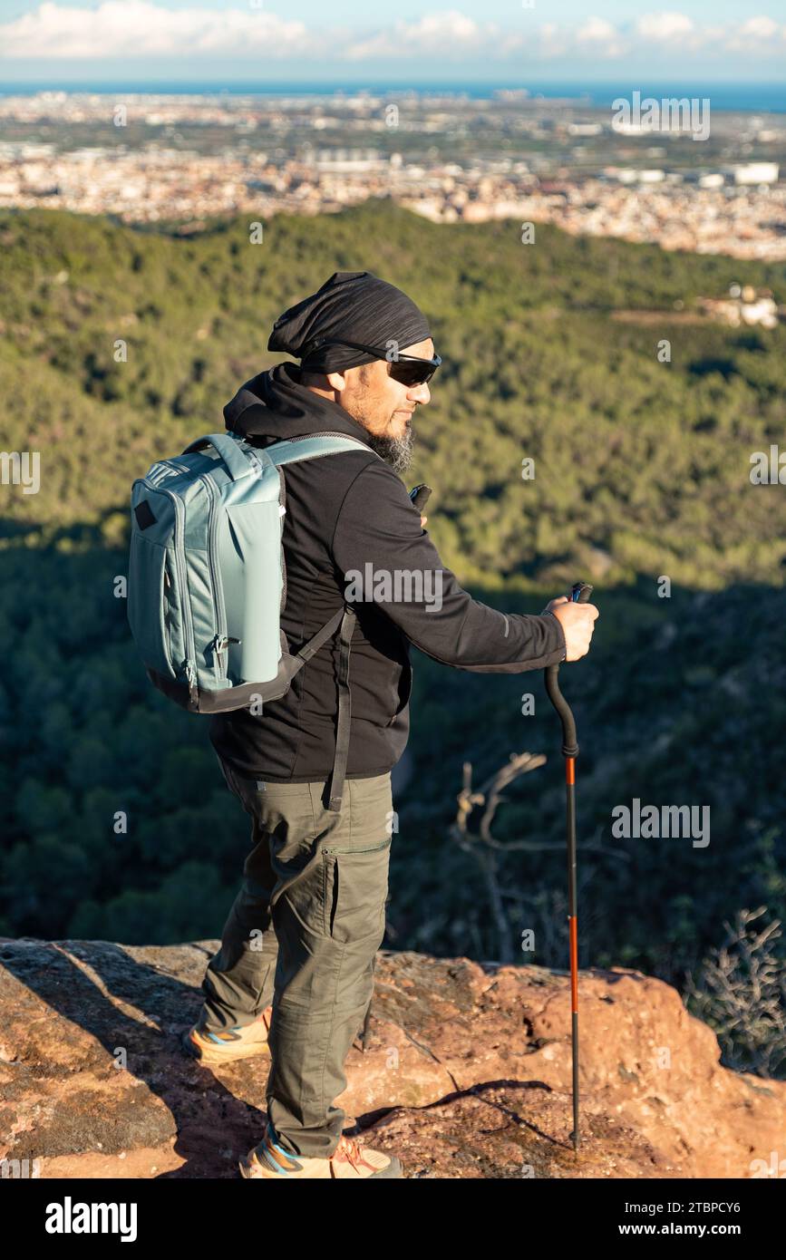 Middle-aged man contemplates the landscapes of the Garraf Natural Park while walking along the trails of a mountain. Stock Photo