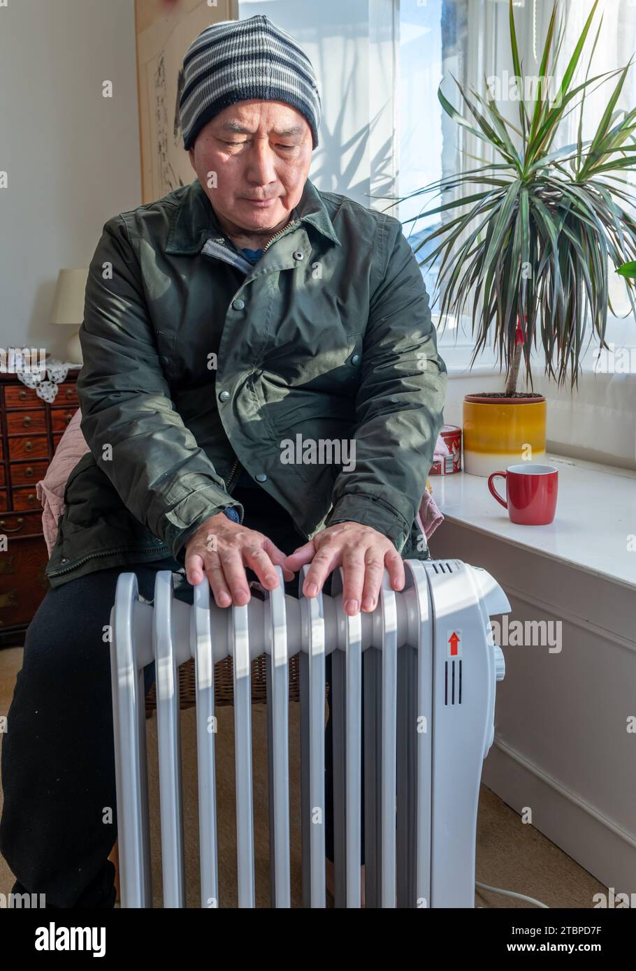 An elderly man fully dressed in the living room sitting next to a