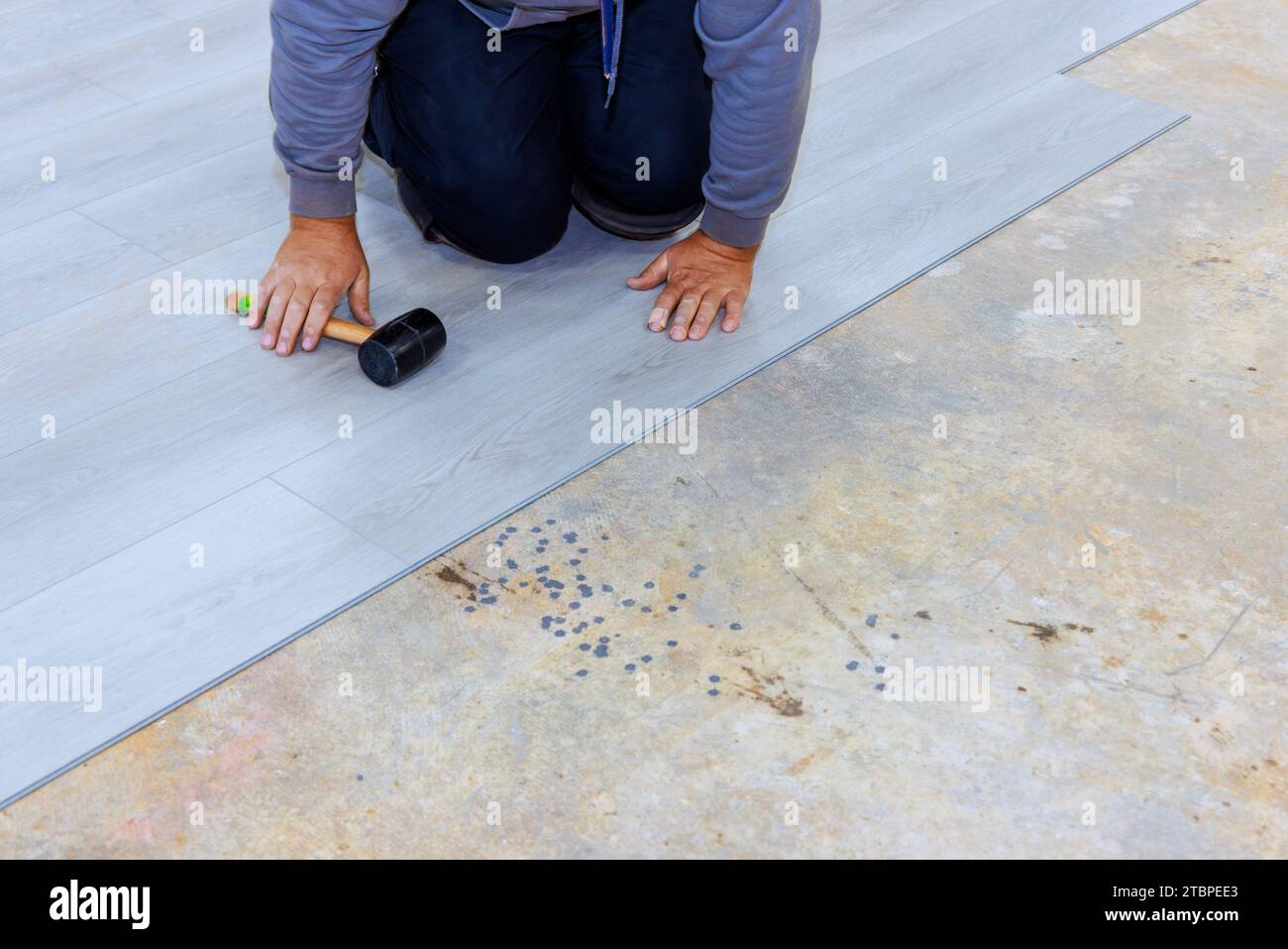 Construction worker installing vinyl laminate flooring in room to new home Stock Photo