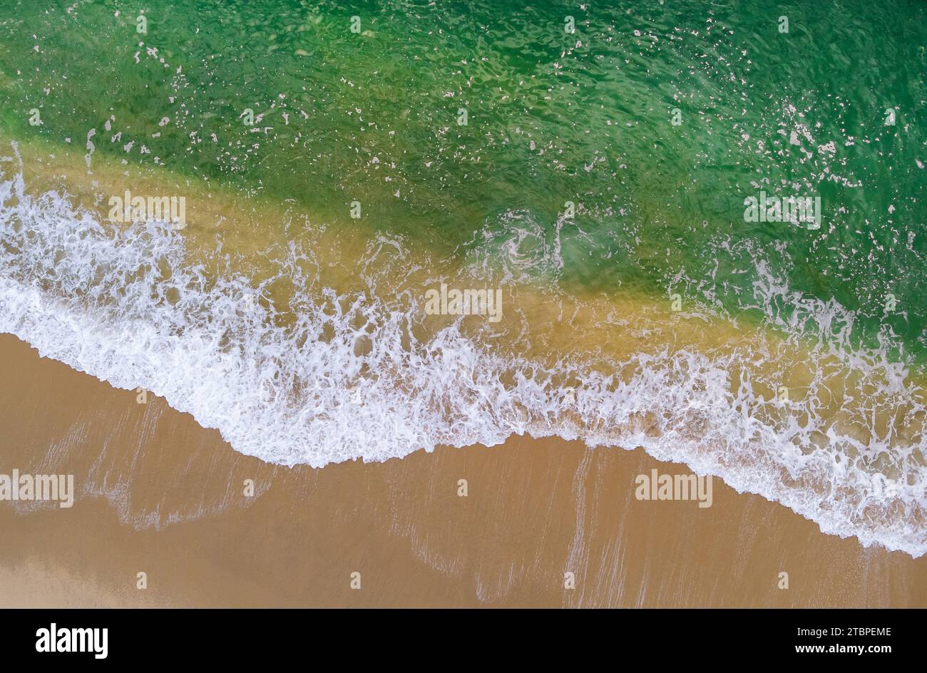 Aerial view of waves crashing on sandy shore, surface ocean waves beach Stock Photo