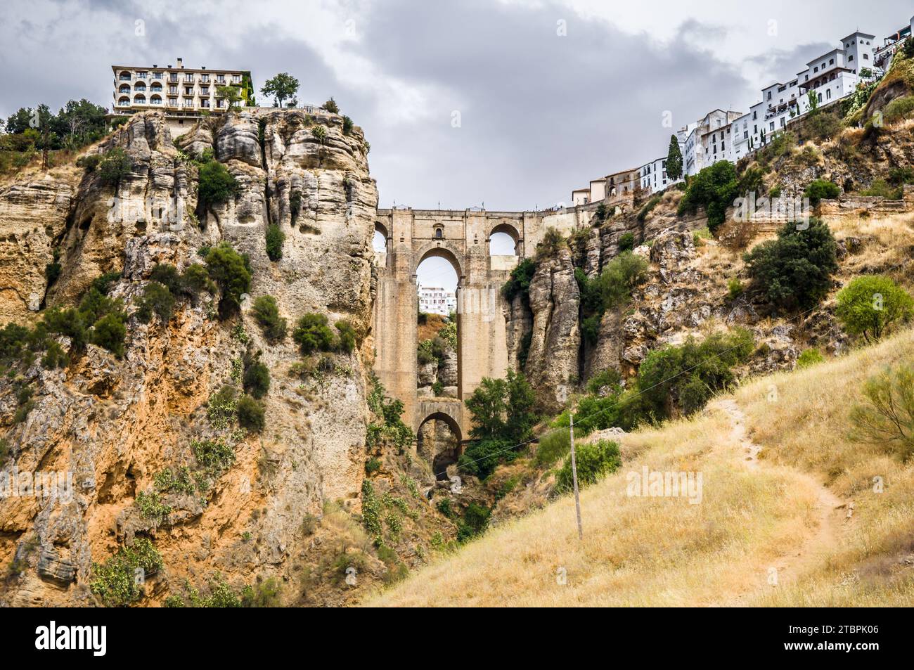 View of a picturesque bridge arching over a rocky hillside, with lush greenery surrounding it Stock Photo