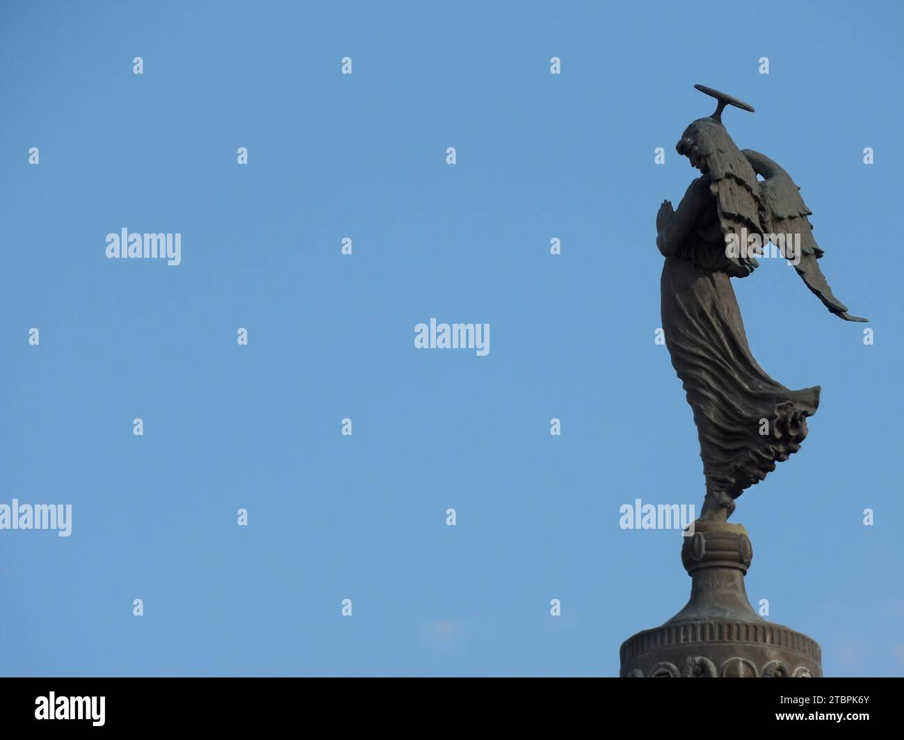 A bronze statue of a figure with a hammer in hand, standing atop a tall building Stock Photo