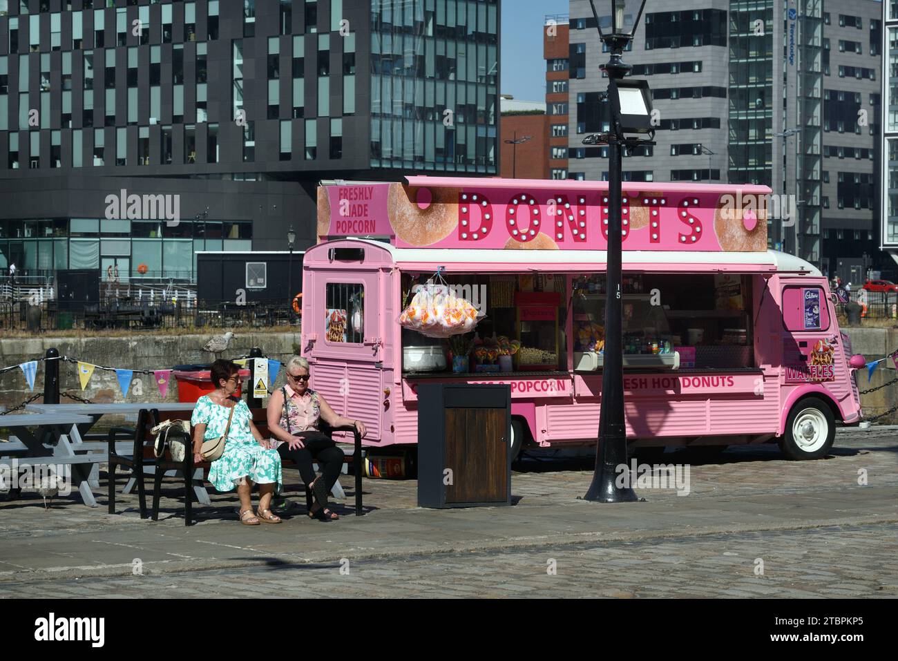 Donut Seller, Donuts or Doughnuts Street Food Truck in Converted Pink Citroen Van on the Waterfront or Pier Head Liverpool England UK Stock Photo