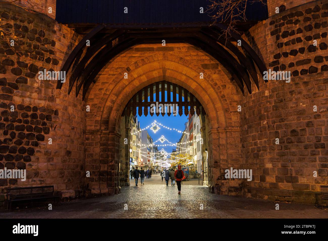 view through the Eigelstein gate to the Christmas-lit Eigelstein street, Cologne, Germany. Blick durch die Eigelsteintorburg zum weihnachtlich beleuch Stock Photo