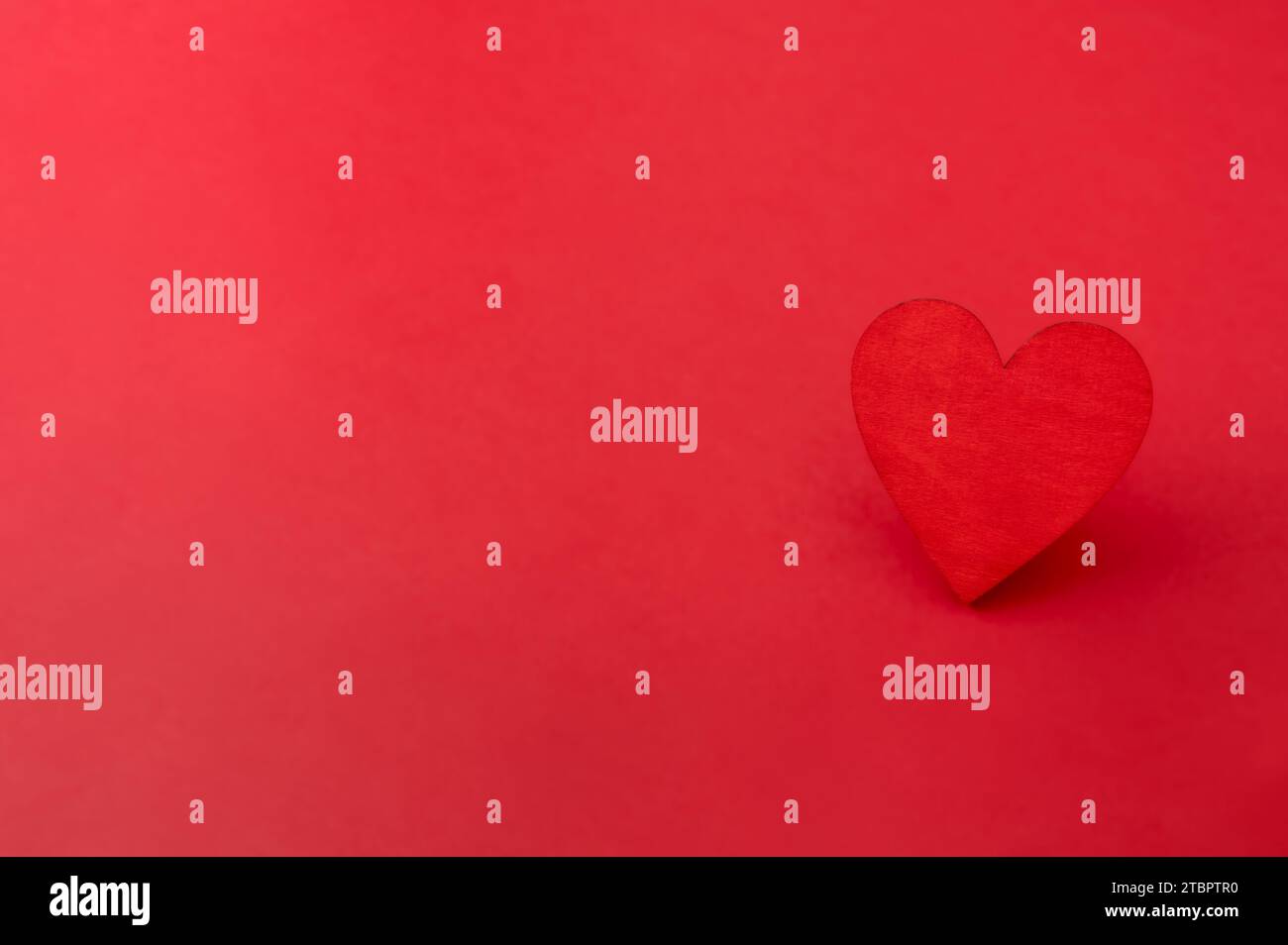 Red wooden heart on red background. Love, valentines day card Stock Photo