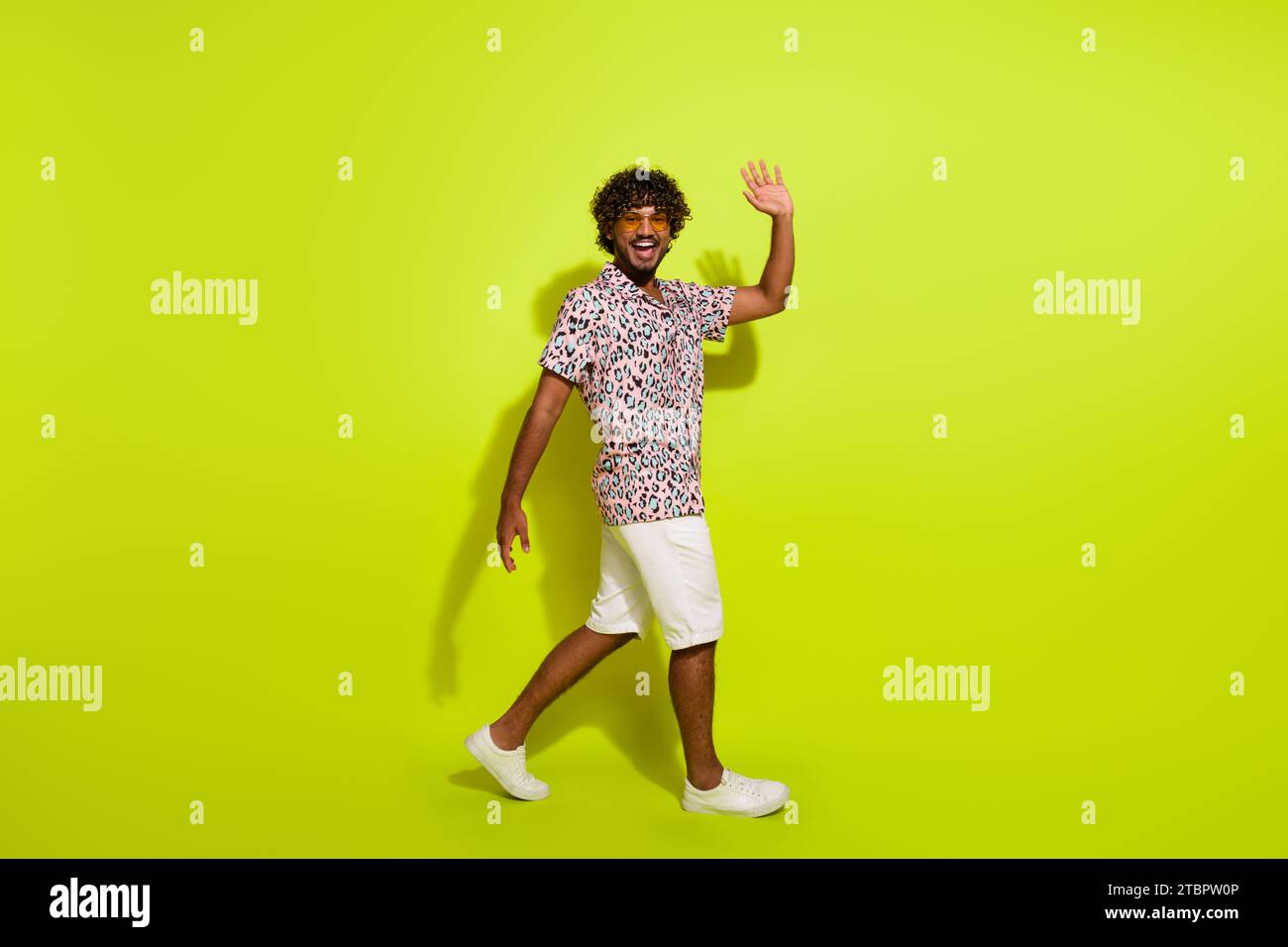 Full body photo of handsome young man walking wave hand hello wear