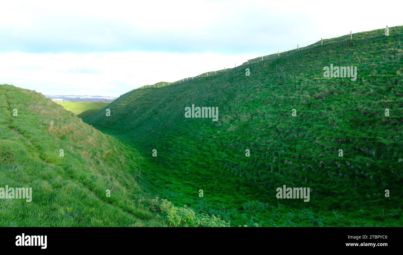 The defensive ditches at the iron age hill fort of Maiden Castle. The largest in the UK - John Gollop Stock Photo