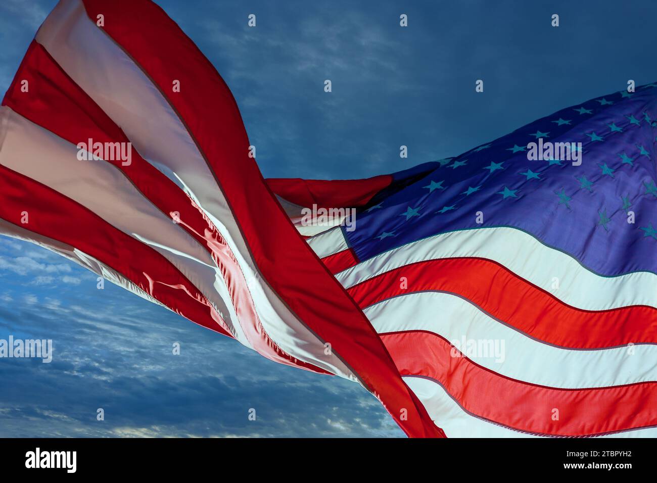 Breeze blows American flag of the United States against blue sky Stock Photo