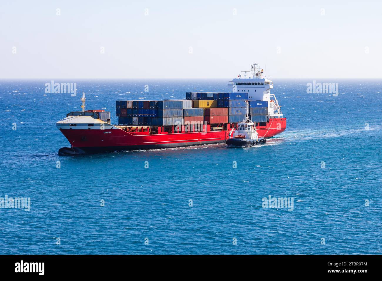 Portuguese container cargo ship, Greta, escorted into Arrecife harbour by tugboat. Lanzarote, Las Palmas, Spain Stock Photo