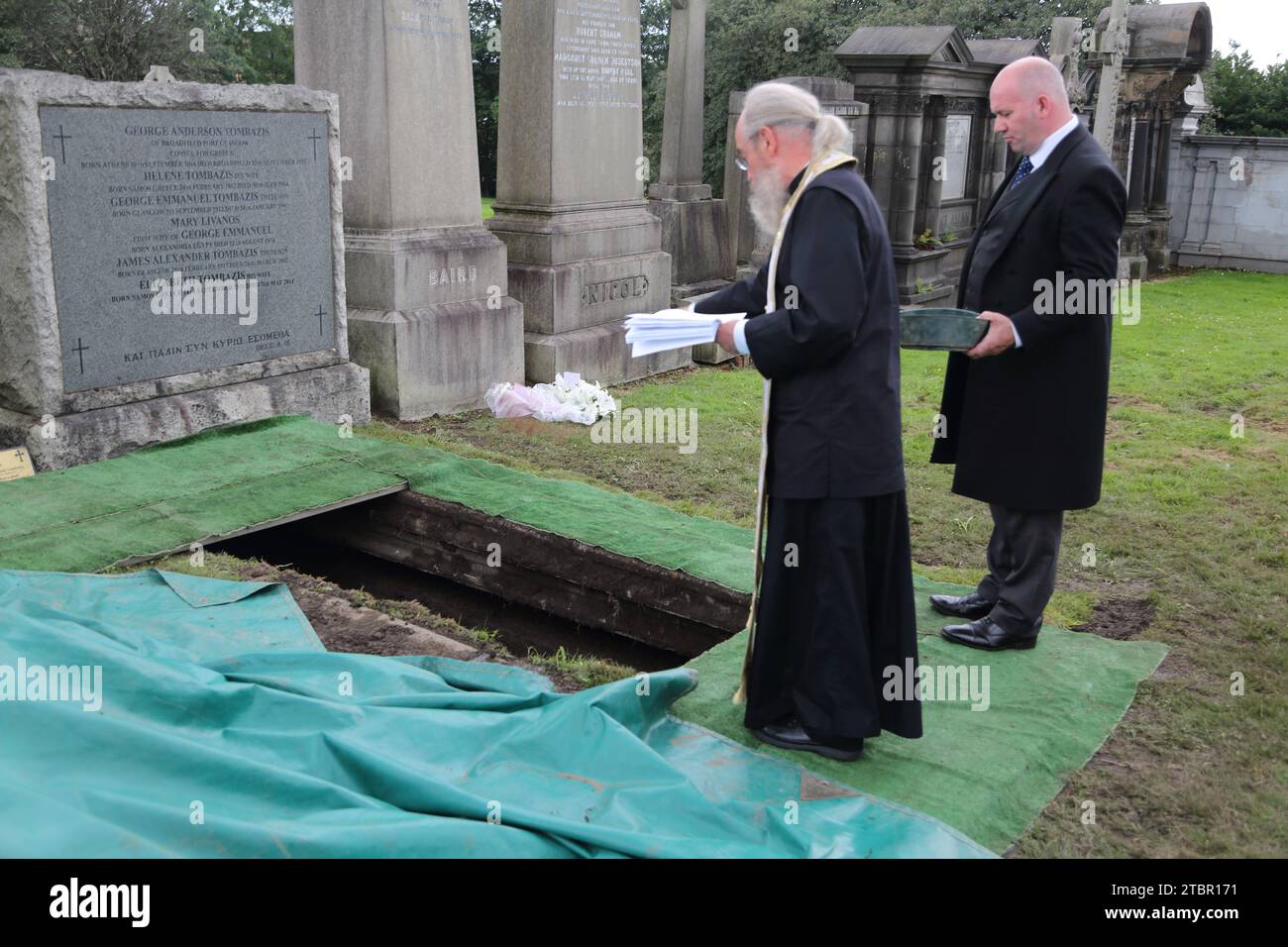 Glasgow Scotland Greek Orthodox Funeral at Glasgow Necropolis - Greek Orthodox Priest throwing Earth over the Coffin at Committal Service Stock Photo