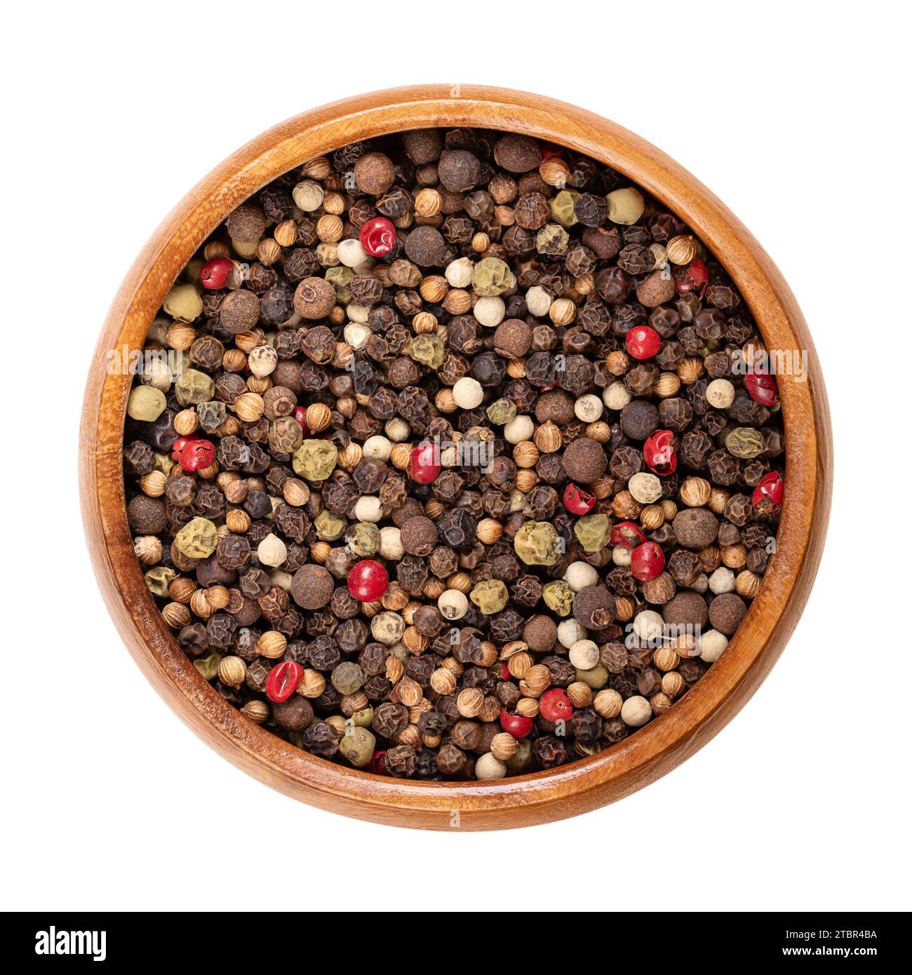 Piquant peppercorn mix in a wooden bowl. Spicy mixture of dried and whole black, green and white and peppercorns, rose pepper, coriander and allspice. Stock Photo