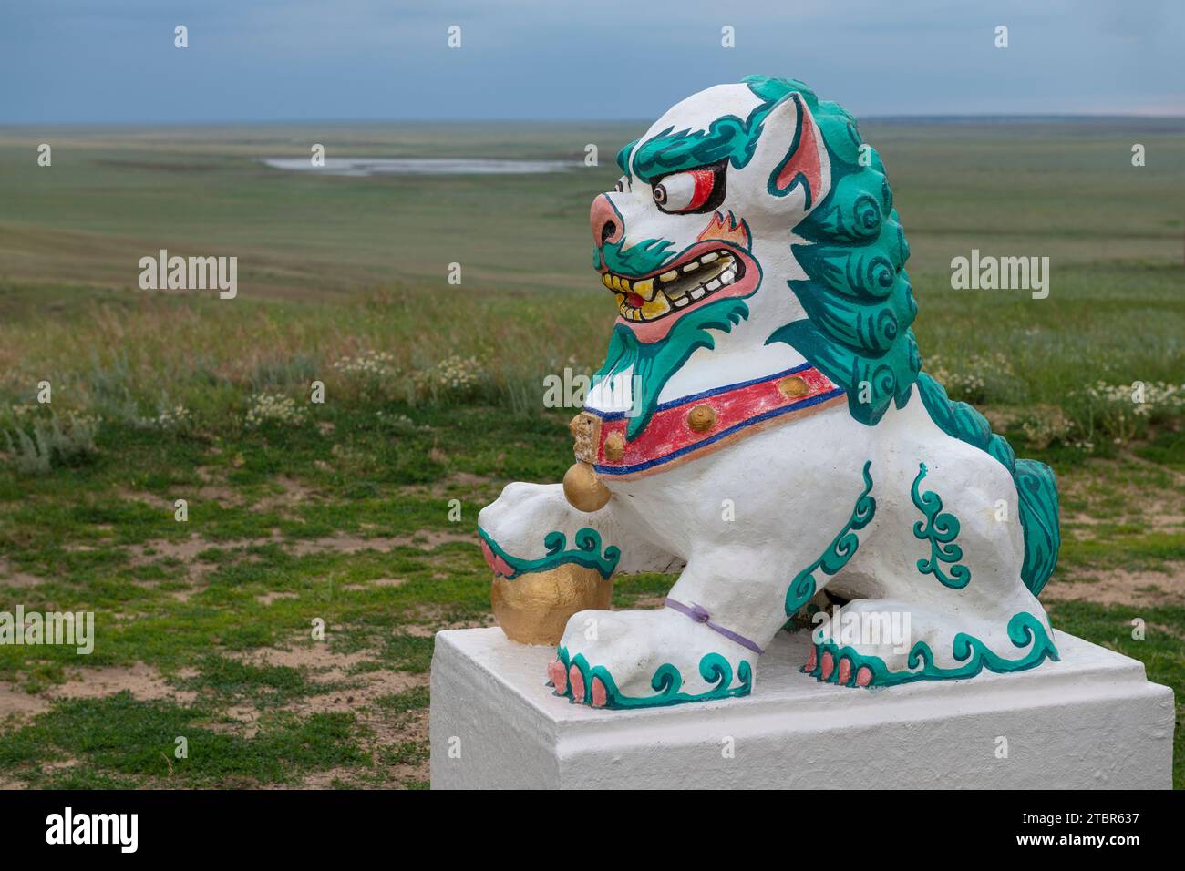 KALMYKIA, RUSSIA - JUNE 04, 2023: Sculpture of a Buddhist lion guard against the background of the Kalmyk steppe on a June evening Stock Photo