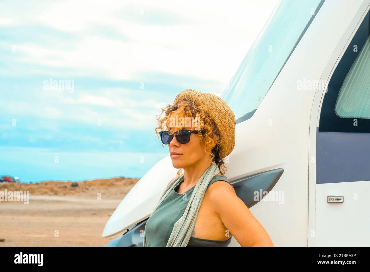 One solo alone woman traveler look outside her modern big camper van motorhome. Concept of living adventure. Nomadic travel lifestyle. Vanlife. Female driver of big vehicle. Scenic independent lady Stock Photo