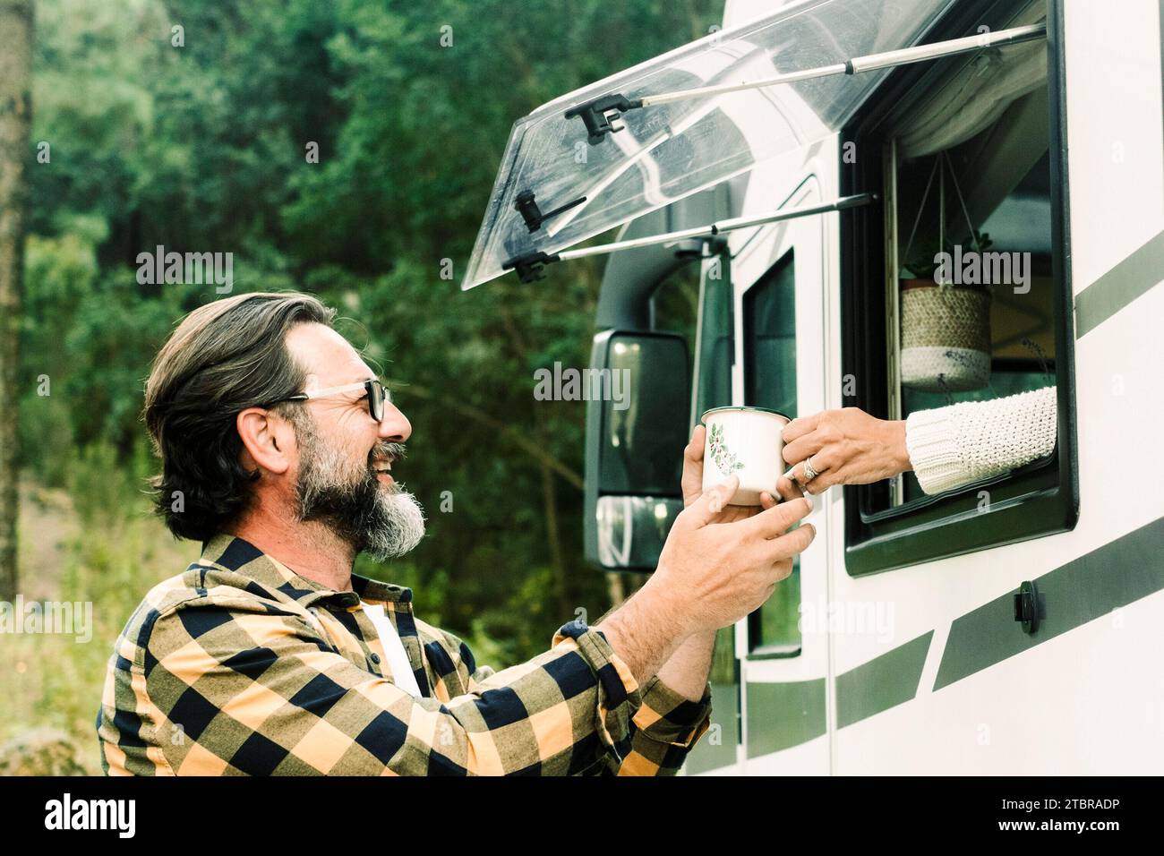 Man and woman enjoying camper van vanlife alternative lifestyle and vacation. People with motorhome alternative house and vehicle rent for holiday. Traveler and nomadic life. Concept of freedom nature Stock Photo