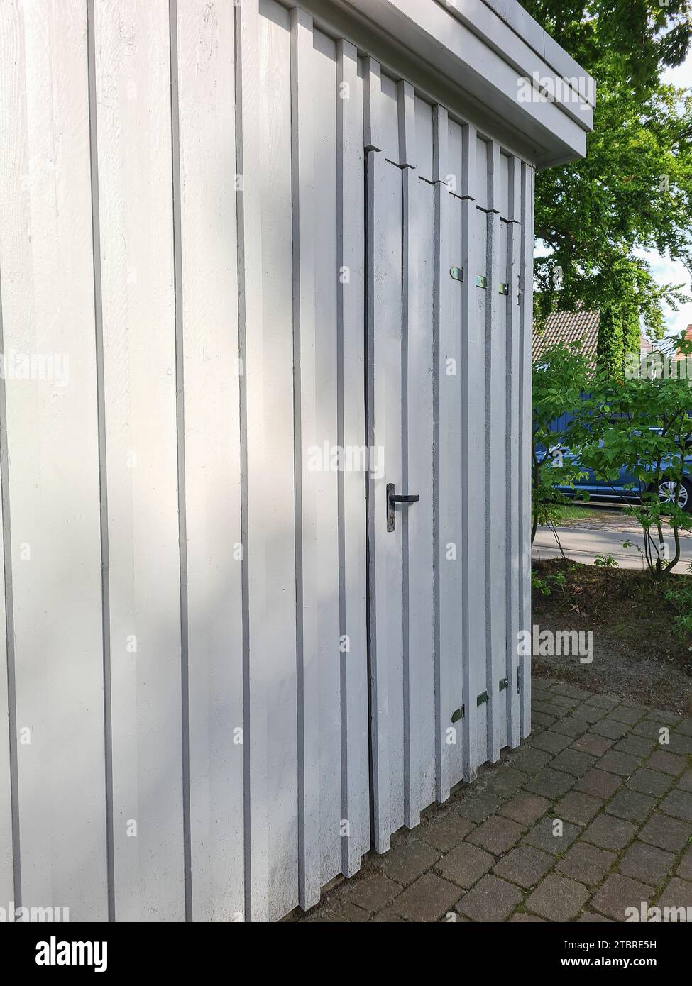 White wooden garage with door as storage room and bike shed, Fischland-Darß-Zingst peninsula, Mecklenburg-Western Pomerania, Germany Stock Photo