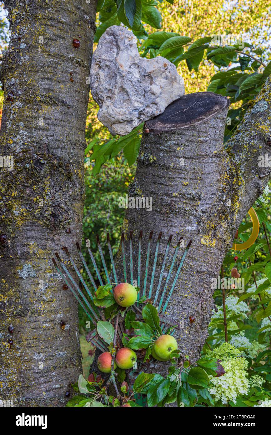 Heart-shaped stone, flotsam and jetsam, leaf broom, garden decoration Stock Photo