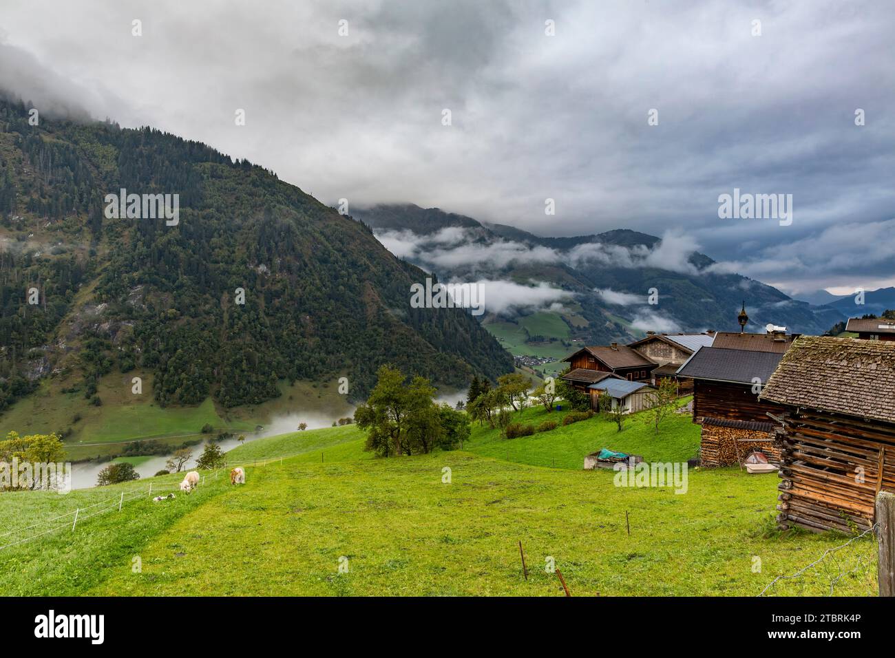 Farmhouses in the morning fog and storm clouds, Fröstlberg in the Rauris Valley, Rauris, Pinzgau, Salzburger Land, Austria Stock Photo