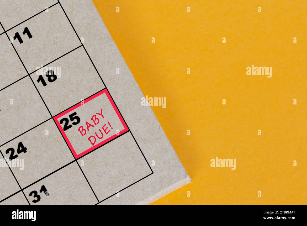 Red mark on the calendar at 25 for reminder of baby due date stock