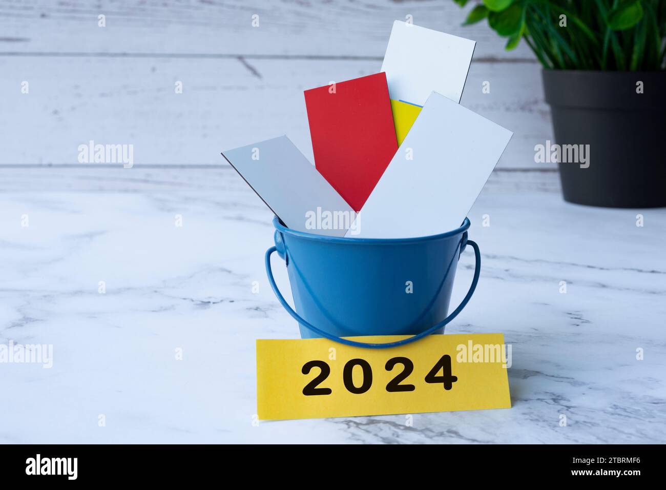 Colorful paper inside of a blue bucket with 2024 label. Stock Photo