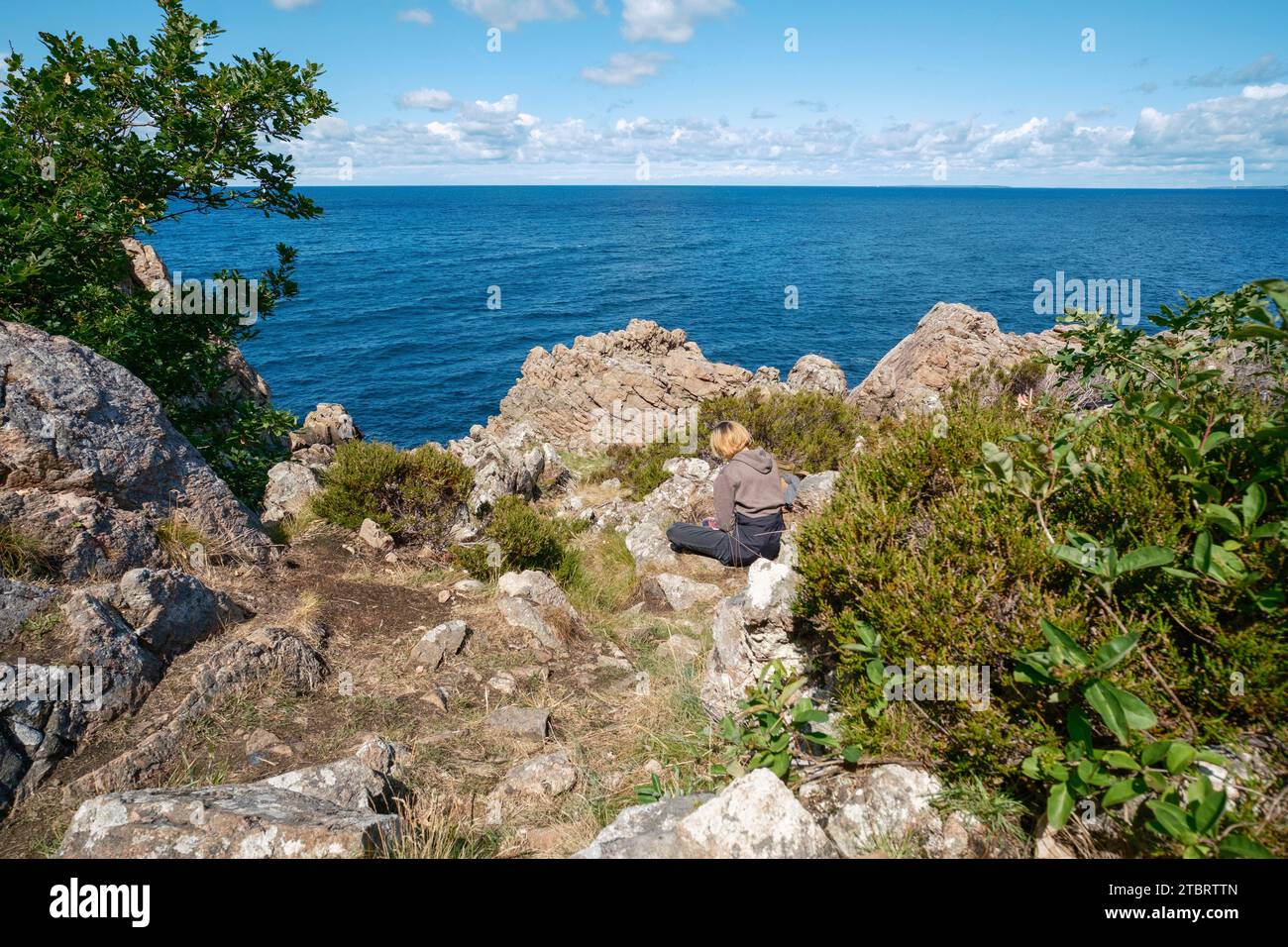 sea-view-from-rugged-rocky-coast-with-person-hi-res-stock-photography