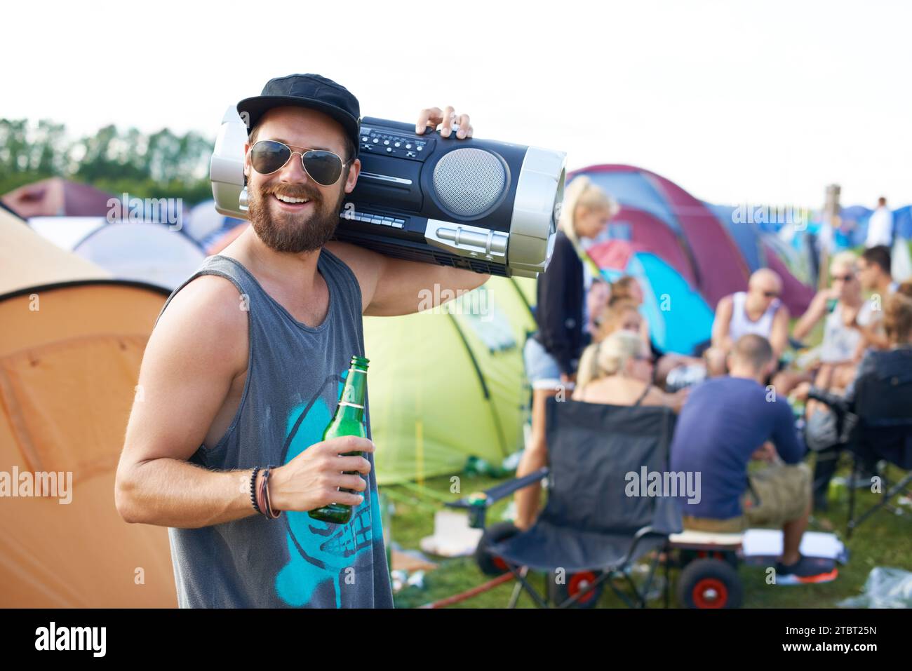 Music festival, alcohol and man with boombox outdoors for social party, celebration and camp event. Happy, excited and person with beer or beverage at Stock Photo