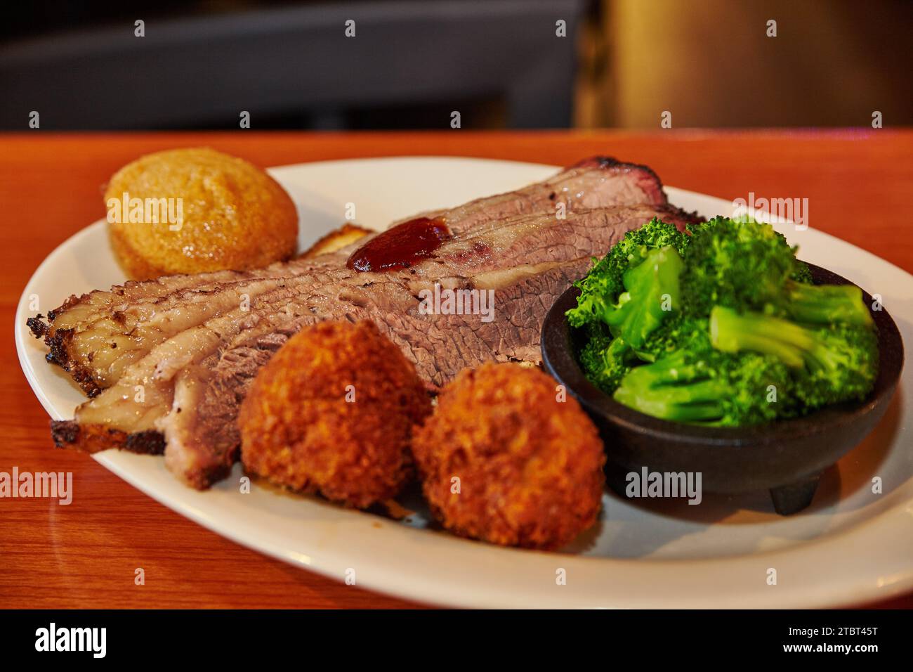 Hearty Southern BBQ Feast with Brisket and Hushpuppies in Restaurant Setting Stock Photo