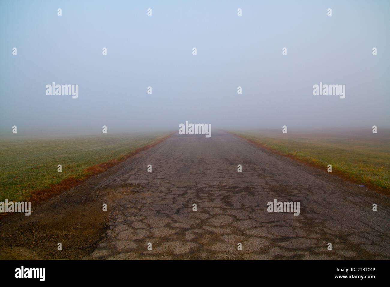 Rural Foggy Road into the Unknown, Worn and Isolated Supernatural Feel Stock Photo