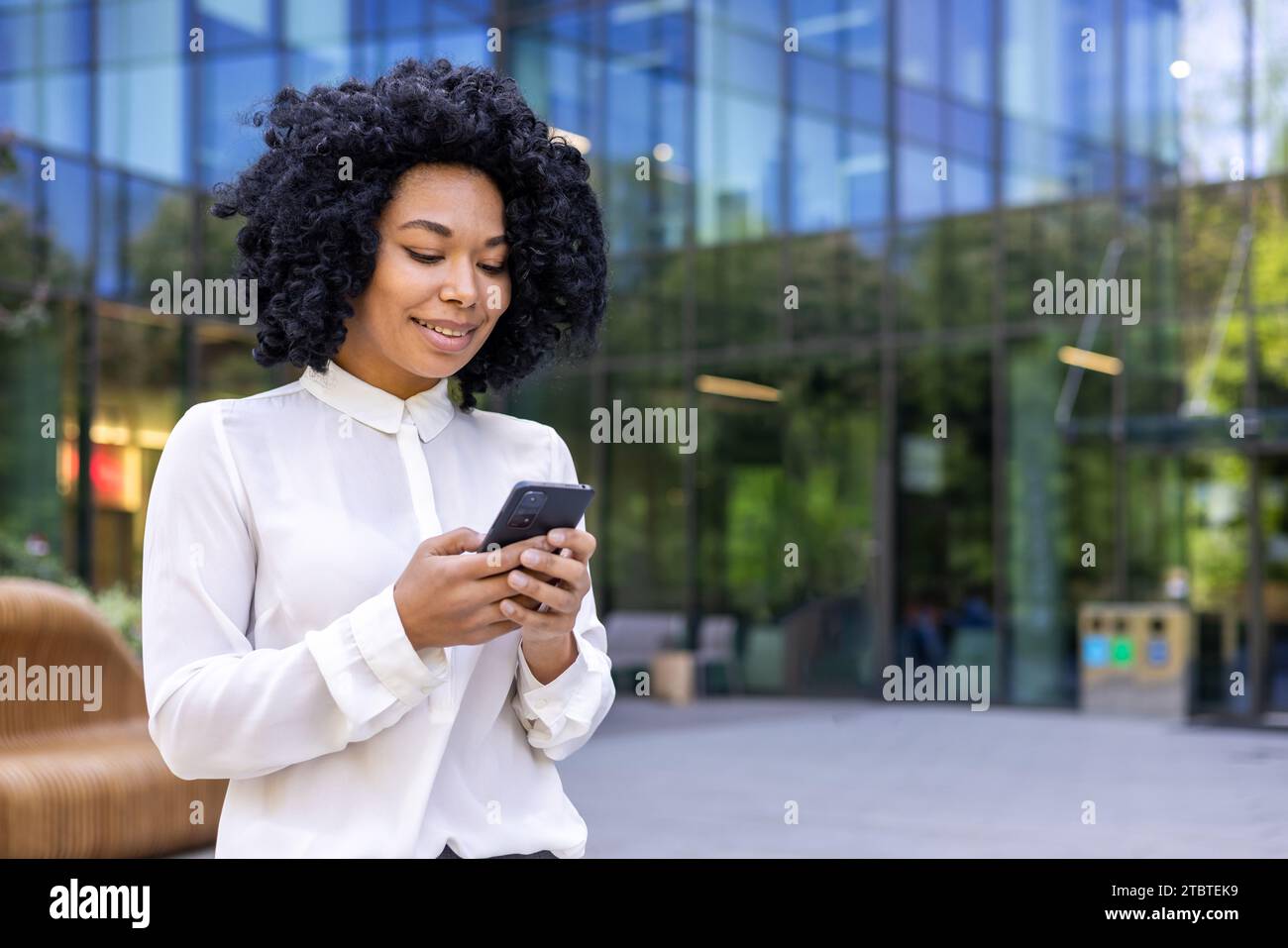 Young beautiful African-American woman walking street outside office ...