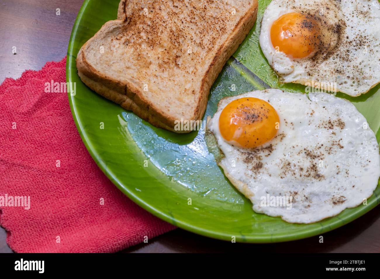 Closeup Image Of Toasted Bread And Sunny Side Up Eggs In Green Plate