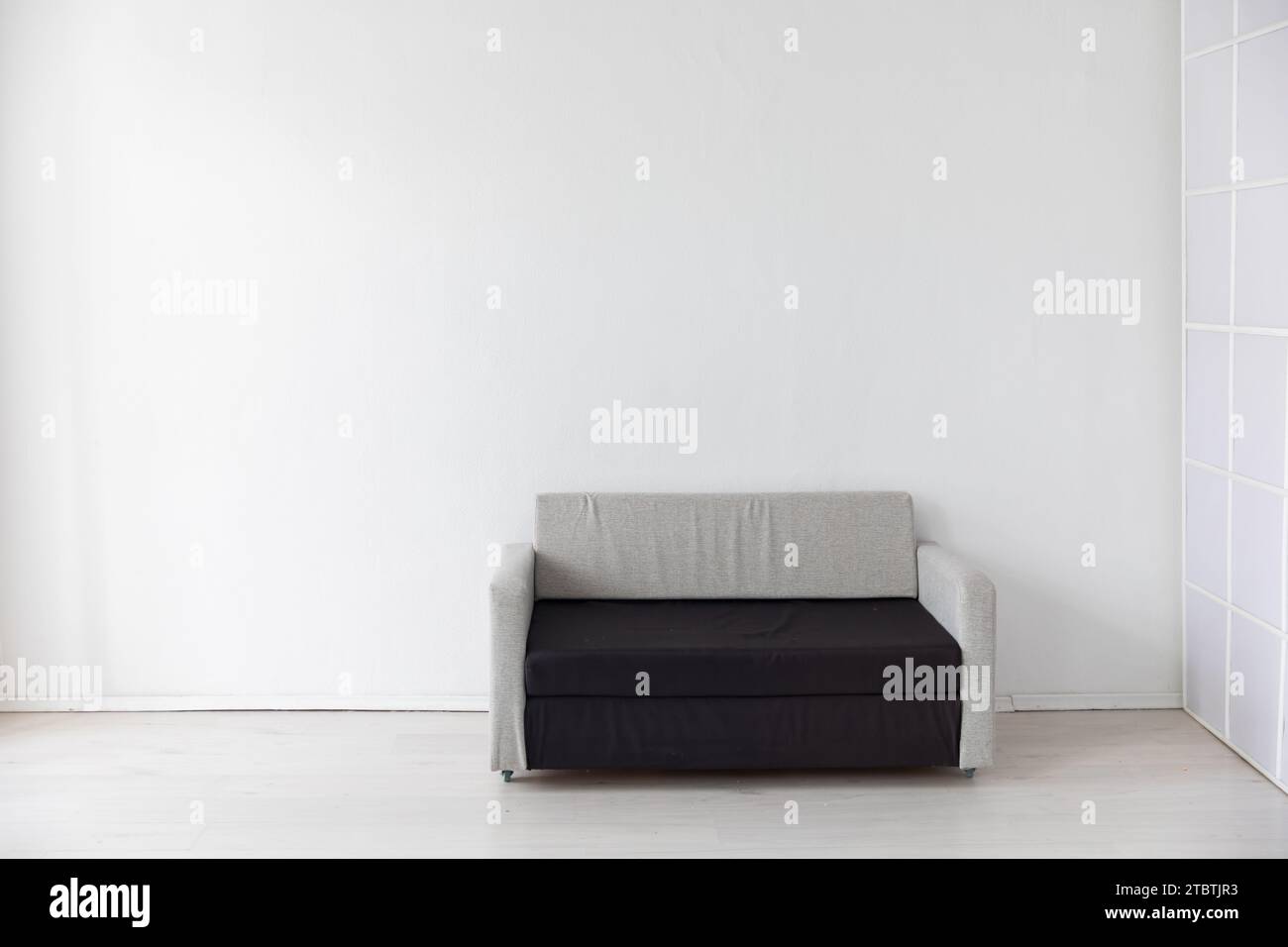 Black and grey office sofa in white room interior Stock Photo - Alamy