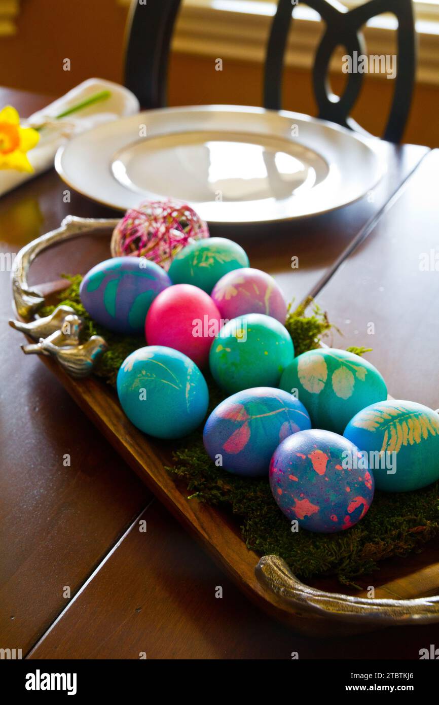 Colorful Handmade Easter Eggs on Rustic Tray in Home Setting Stock Photo
