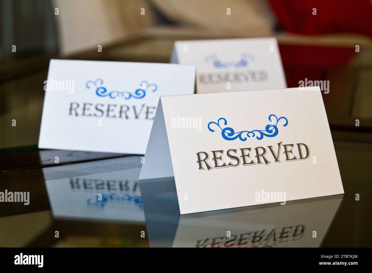 Reserved Signs with Ornate Blue Design on Reflective Glass Surface ...