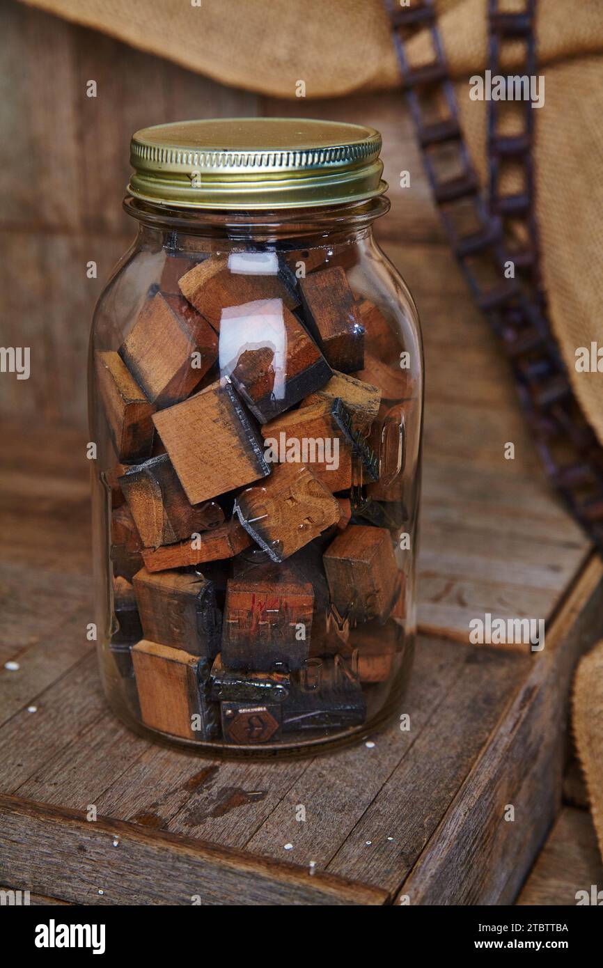 Vintage Wooden Letterpress Blocks in Glass Jar on Rustic Background Stock Photo