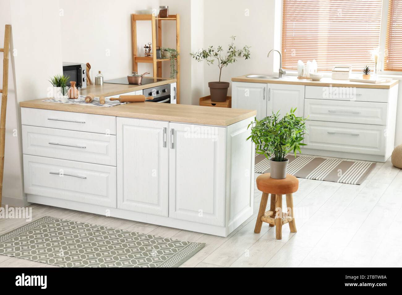 Interior of light kitchen with white counters and carpets Stock Photo ...
