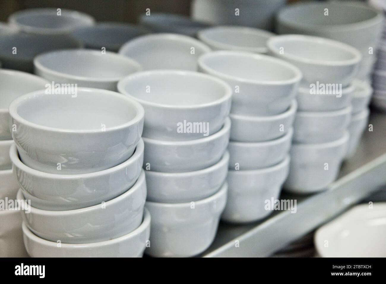 Neatly Stacked White Ceramic Bowls in Brightly Lit Kitchenware Store Stock Photo