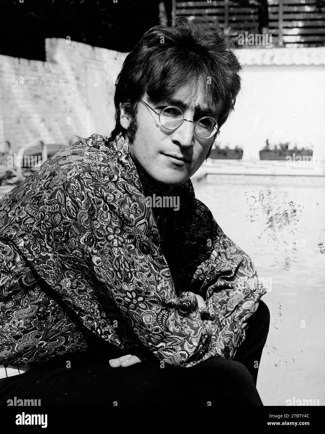 July 24, 1968 - London, England, United Kingdom - Singer/Songwriter JOHN LENNON (1940-1980) member of The Beatles relaxing at his home. Today marks the 25th anniversary of the death of JOHN WINSTON LENNON. He was born on Oct. 9th, 1940 in Liverpool and was best known as a singer, songwriter, poet and guitarist for The Beatles. He is recognized as one of the greatest musical icons of the 20th century. On the evening of Dec. 8th, 1980, in New York City, deranged fan Mark David Chapman shot Lennon 4 times in the back and shoulder. Despite extensive resuscitative efforts, Lennon died of shock and Stock Photo