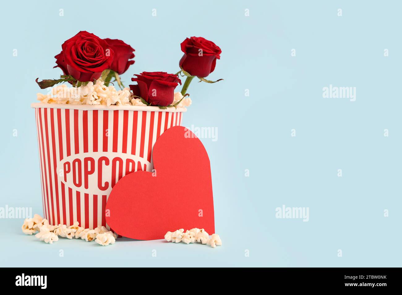 Popcorn At Roses Bucket of popcorn with beautiful red roses and paper heart on blue ...