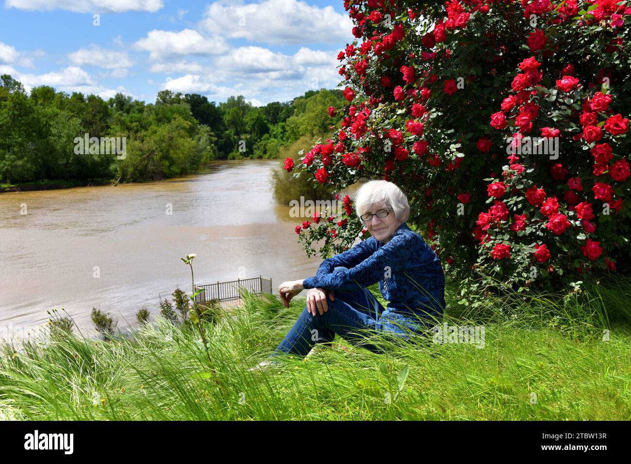 Elderly woman sits on the banks of the Ouachita River and observes the ...