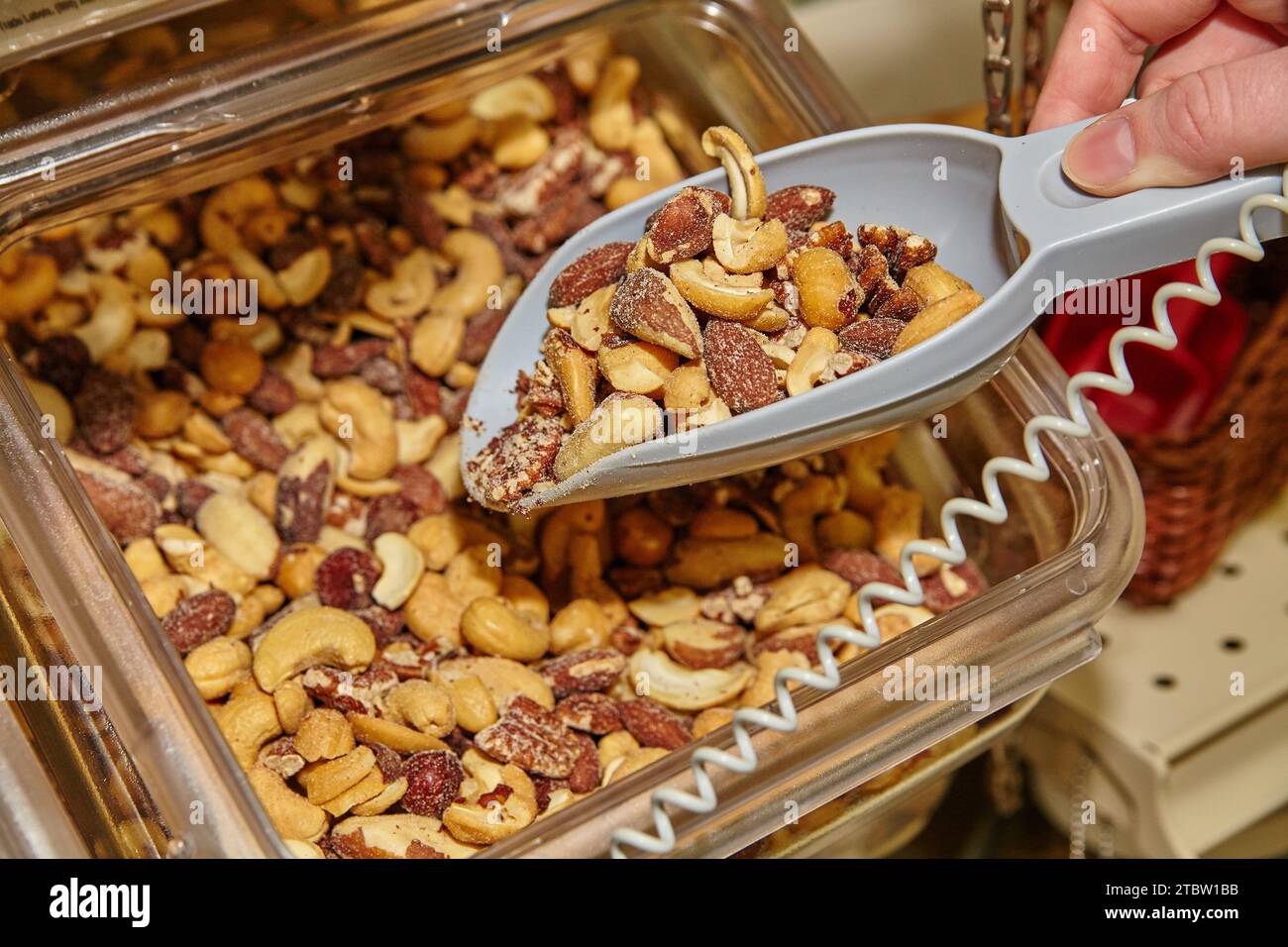 Scoop of Mixed Nuts in Bulk Bin at Health Food Store Stock Photo