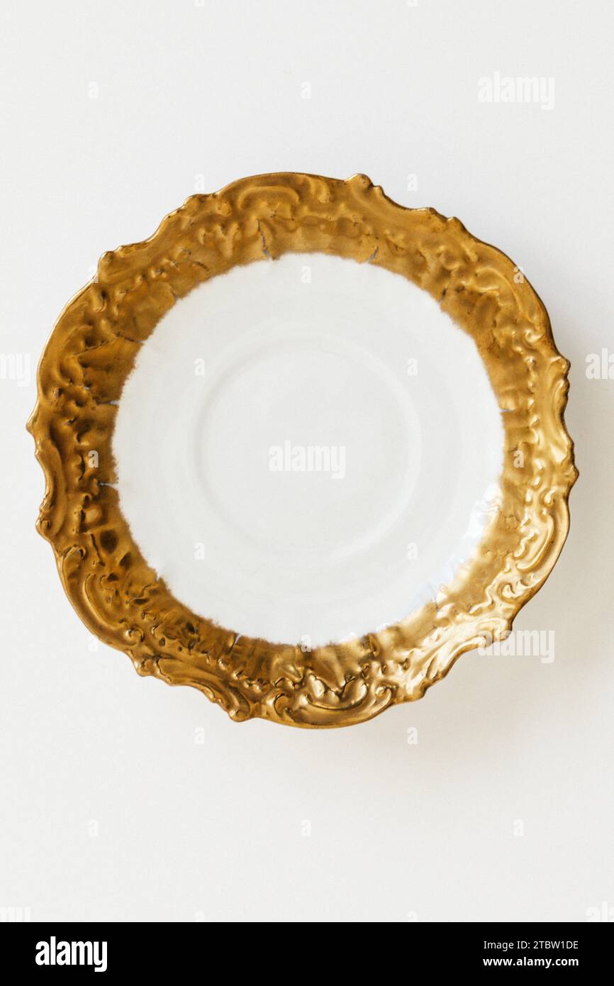 Limoges France Gold and White embossed, scalloped, scrolled edge saucer circa 1891-1914 Stock Photo