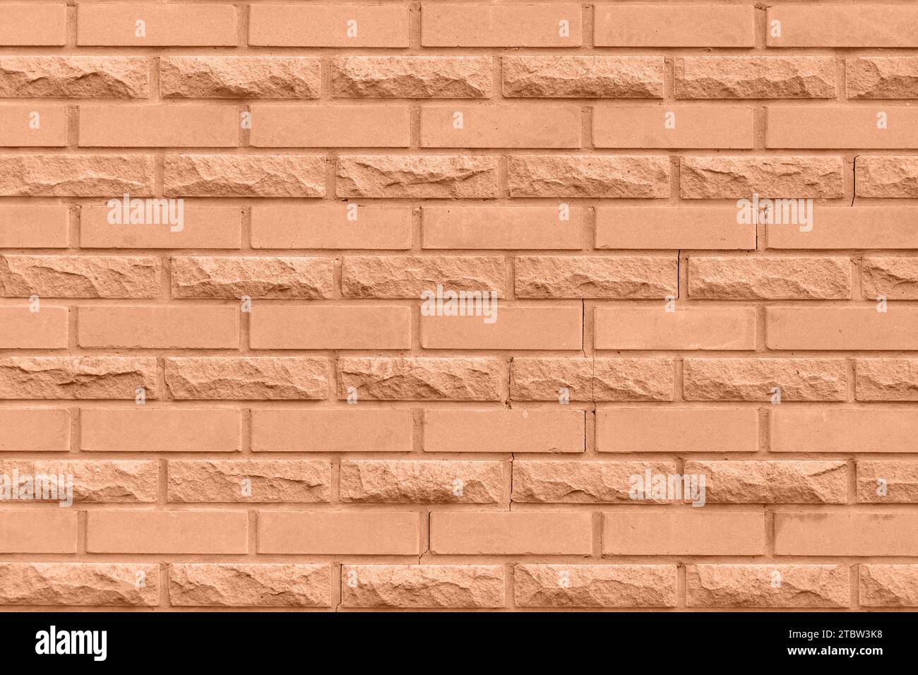 Solid peach brick wall. Brick background. Showcasing the color of 2024
