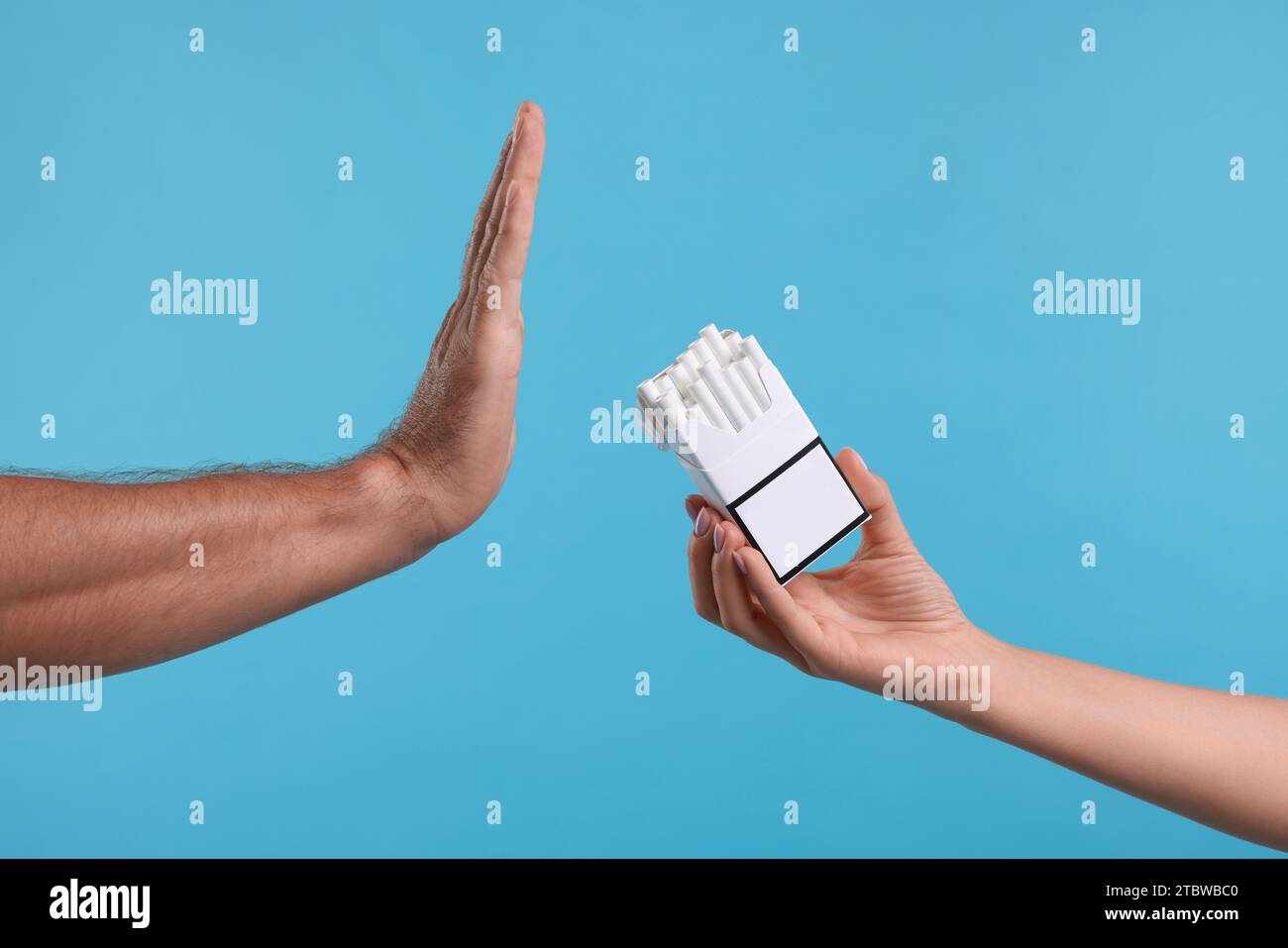 Stop smoking concept. Man refusing cigarettes on light blue background ...