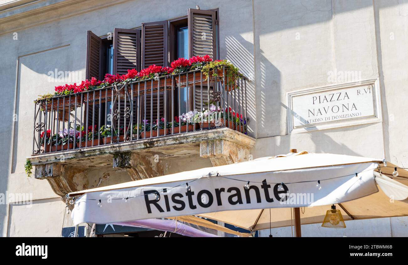 A picture of a restaurant awning, a picturesque balcony and the Piazza Navona plaque Stock Photo