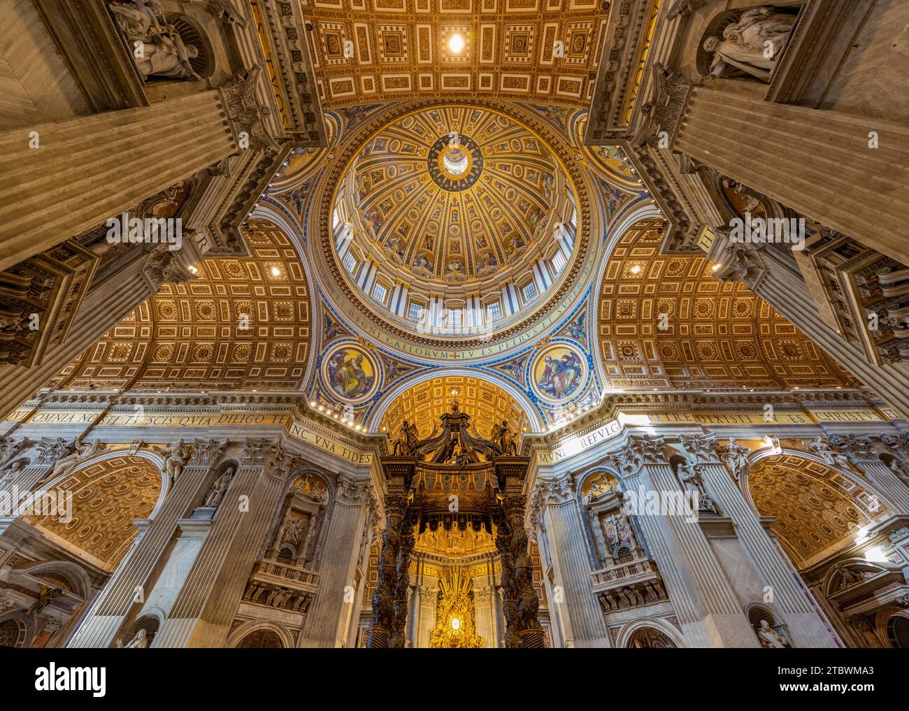A picture of the huge dome of the St. Peter's Basilica, the altar and the surrounding frescoes and architecture as seen from the inside Stock Photo