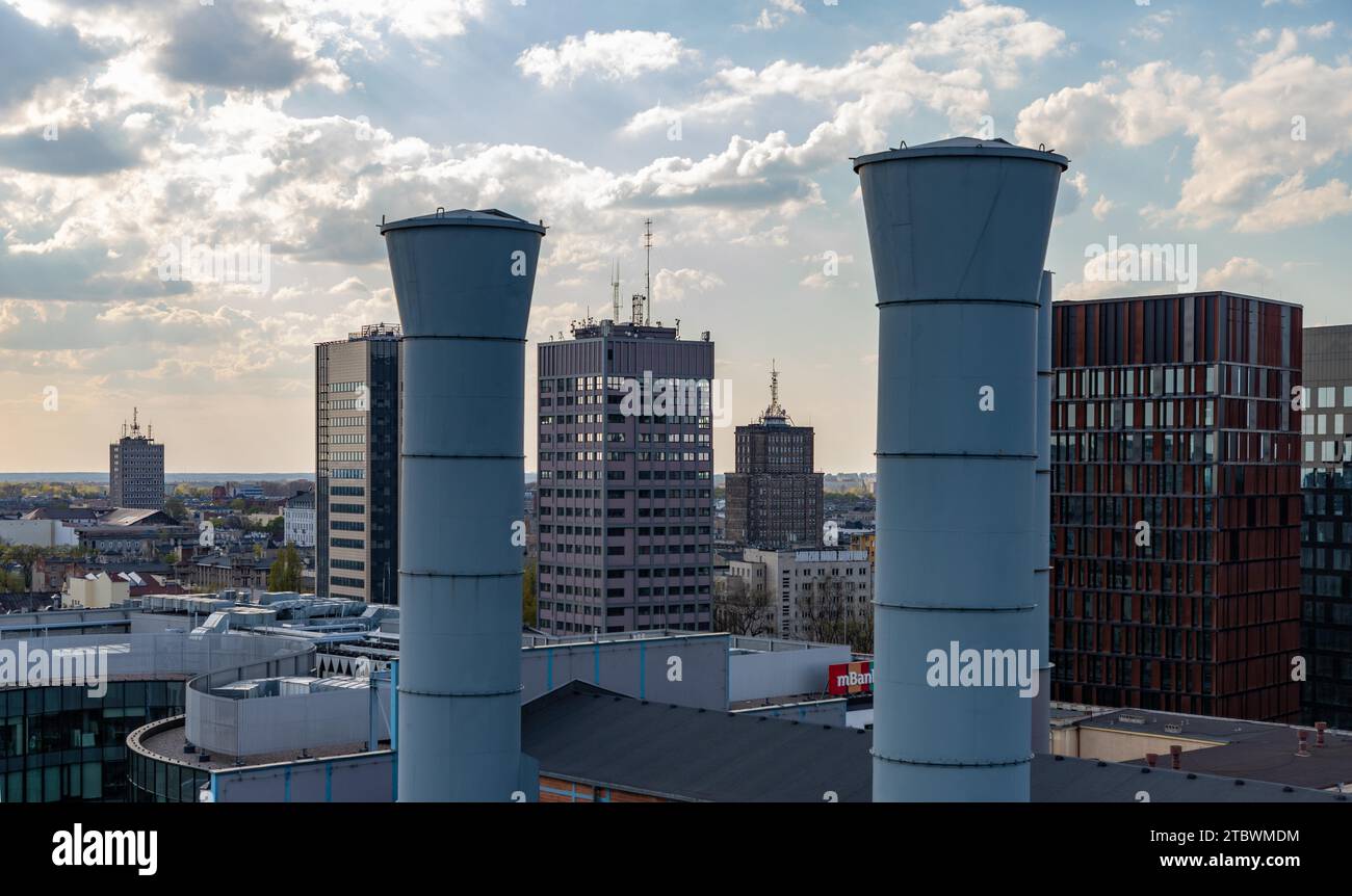 A panoramic picture of some rooftops and buildings of ?od?, alternating with two large chimneys from the EC1 ?od?, City of Culture complex Stock Photo